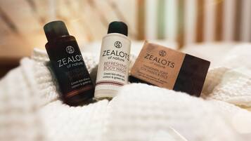 Tres botellas y una caja de productos Zealots of Nature sobre una superficie blanca con textura.