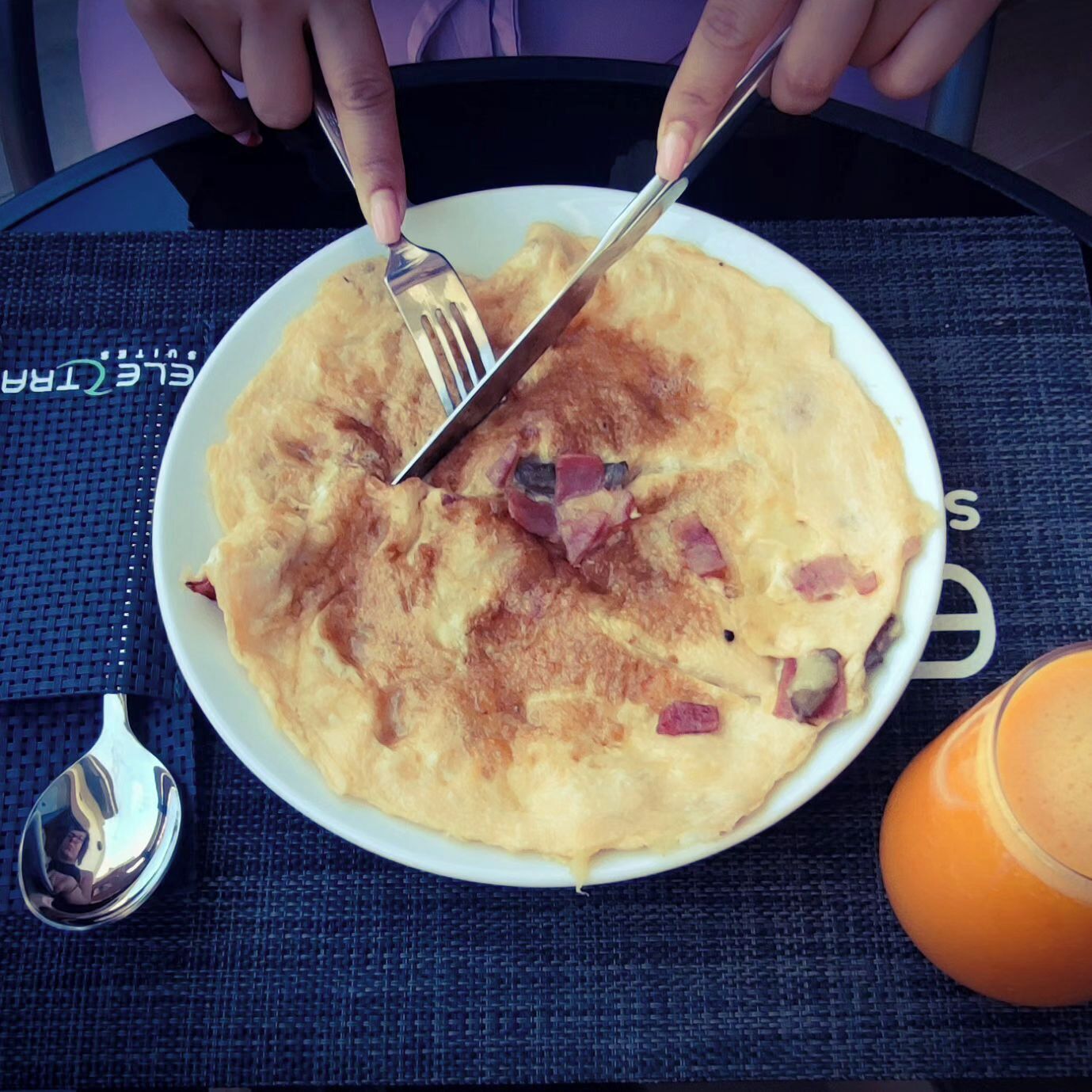 Un plato de comida con tenedor y cuchillo sobre una mesa.