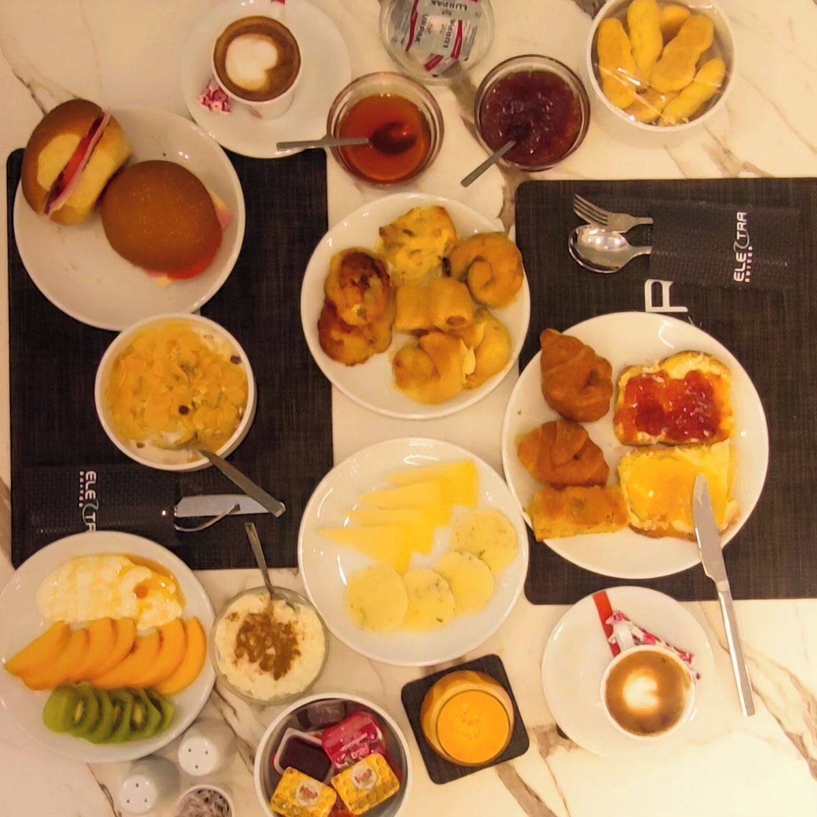 A breakfast buffet with various dishes including pancakes, eggs, fruit, and pastries.