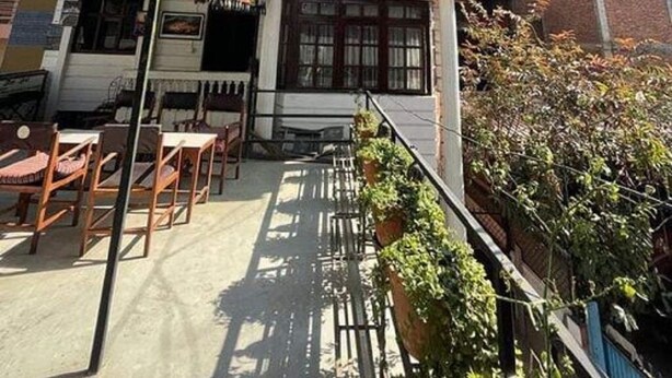 A multi-story building with a balcony on the second floor, a small shop on the ground floor, and a staircase leading to the entrance. - Centrally located at west Thamel quite Location 5 stories Apartment  (Kathmandu)
