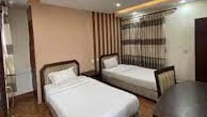 A hotel room with two single beds, a desk, and a wardrobe. - Centrally located at west Thamel quite Location 5 stories Apartment  (Kathmandu)