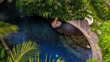 Een buitenzwembad, parasols bij het zwembad en ligstoelen