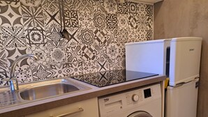 A compact kitchen with a washing machine, a sink, and a refrigerator. - A due passi da Camogli (Recco)