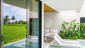 Un área de piscina interior moderna con un ventanal que da a un exuberante paisaje verde.