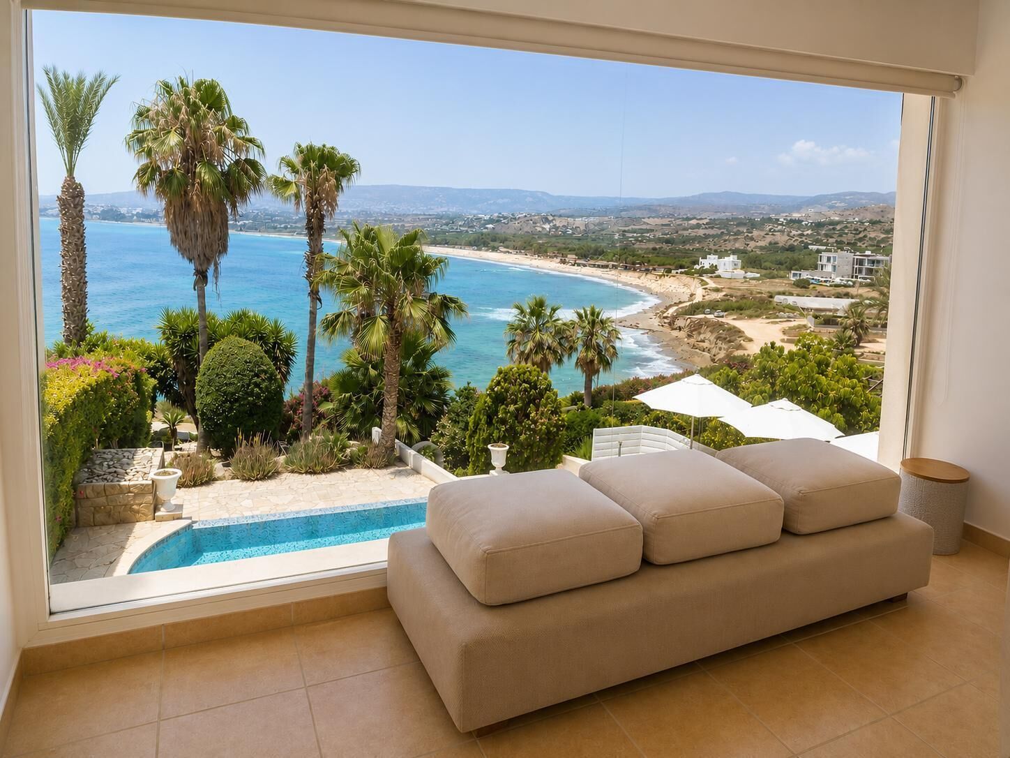 A balcony with a view of a beach, a pool, and a sofa.
