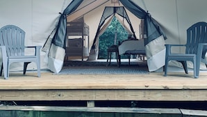 A tented accommodation with a wooden deck, two chairs, a table, and a hanging fan. - Luxury Spacious Glamping, Lake View, Grill, Pool, Pet Friendly, Swim (Delta)