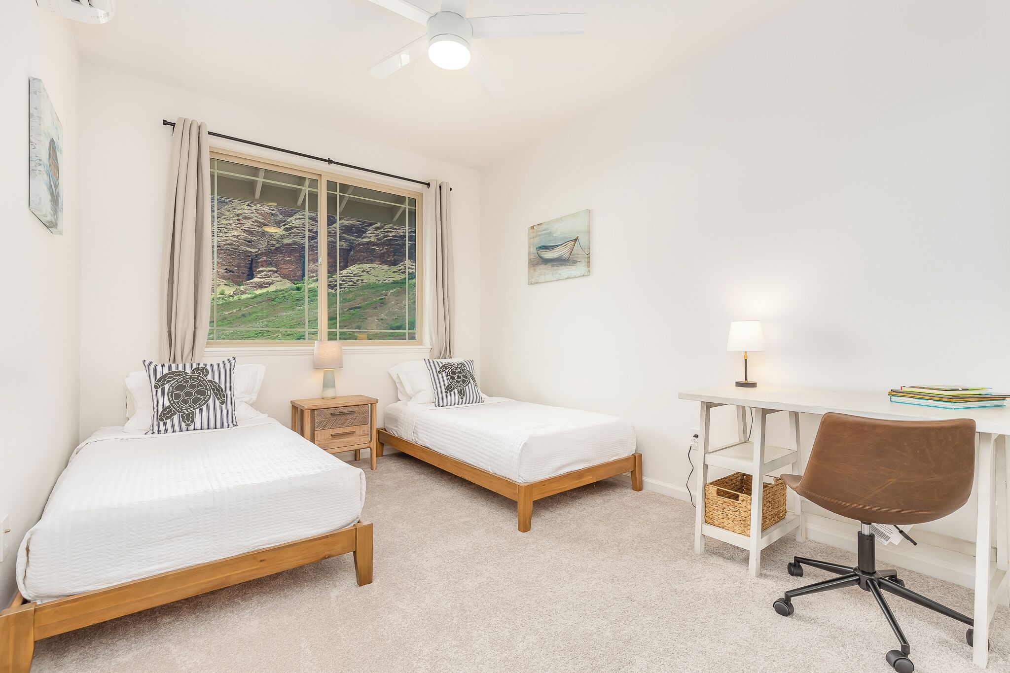 Un dormitorio con dos camas individuales, un escritorio con silla, una ventana con cortinas y un ventilador de techo.