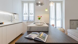 A modern kitchen with a marble countertop, a built-in sink, and pendant lighting. - Design Premium apartment in center Milan-HomeUnity (Milano)