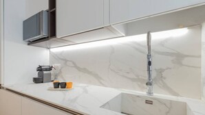 A modern kitchen with a marble countertop, a built-in sink, and a stainless steel faucet. - Design Premium apartment in center Milan-HomeUnity (Milano)