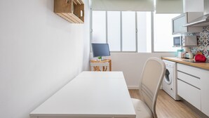 A compact kitchen with a white table, a washing machine, and a microwave. - Las Canteras Beach - Bright Studio - Workfriendly (Las Palmas de Gran Canaria)