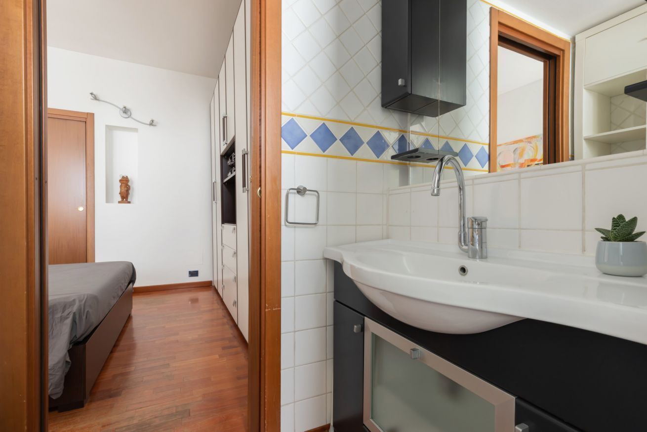 Une chambre à coucher de taille réduite, comprenant un lit, une petite table de chevet et une commode.