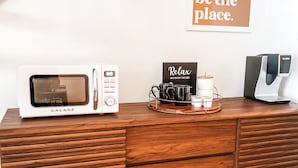 A wooden cabinet with a microwave, a coffee machine, and a tray with mugs and a sign that says "Relax and enjoy the WiFi." - Condo with loft near Loon mountain with pool/jacuzzi & free shuttle! (Lincoln)