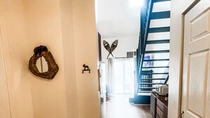 A hallway with wooden flooring, white walls, and a blue staircase. - Condo with loft near Loon mountain with pool/jacuzzi & free shuttle! (Lincoln)