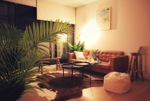 Relax in this inviting living space with a comfortable sofa, coffee table, and potted plant.