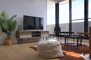 Relax in this stylish living room with a large flat-screen TV, comfortable sofa, and natural views.
