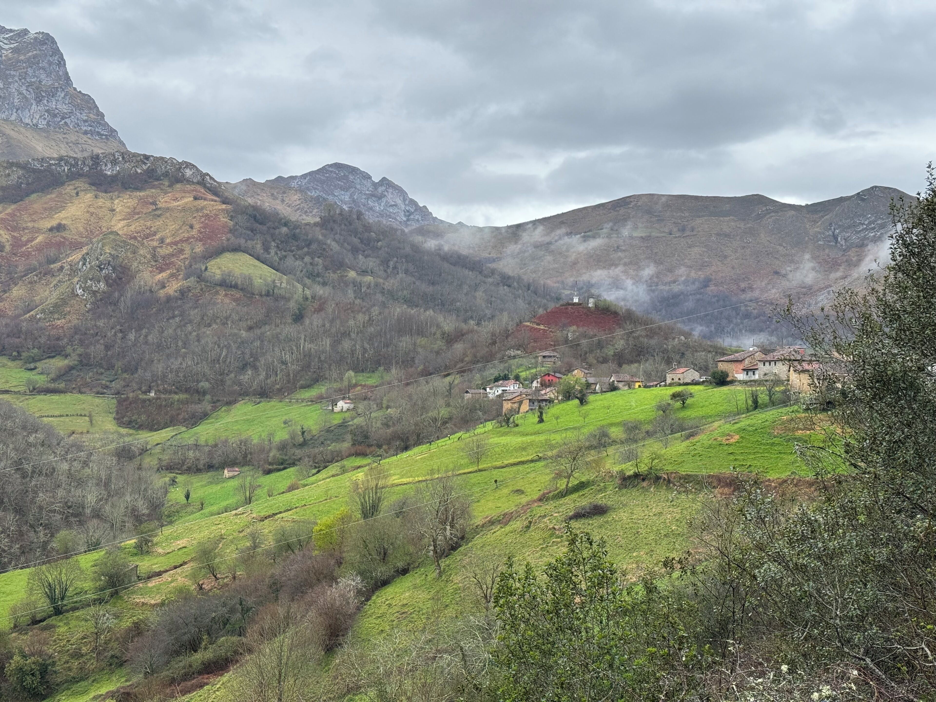 A mountainous landscape with a small village nestled among green hills.