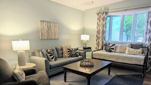 Un salon avec deux canapés, une table basse et une lampe.