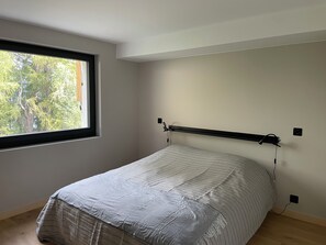 A bedroom with a bed, a window, and a wall-mounted shelf. - Chalet La Source (Nendaz)