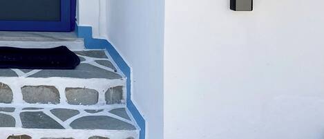 A white building with a blue door and a number '1' on the wall.