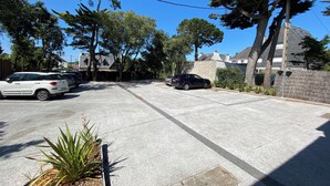 A parking lot with several cars, surrounded by trees and buildings.