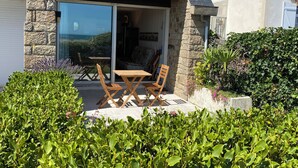 A stone house with a patio, a table, and chairs.