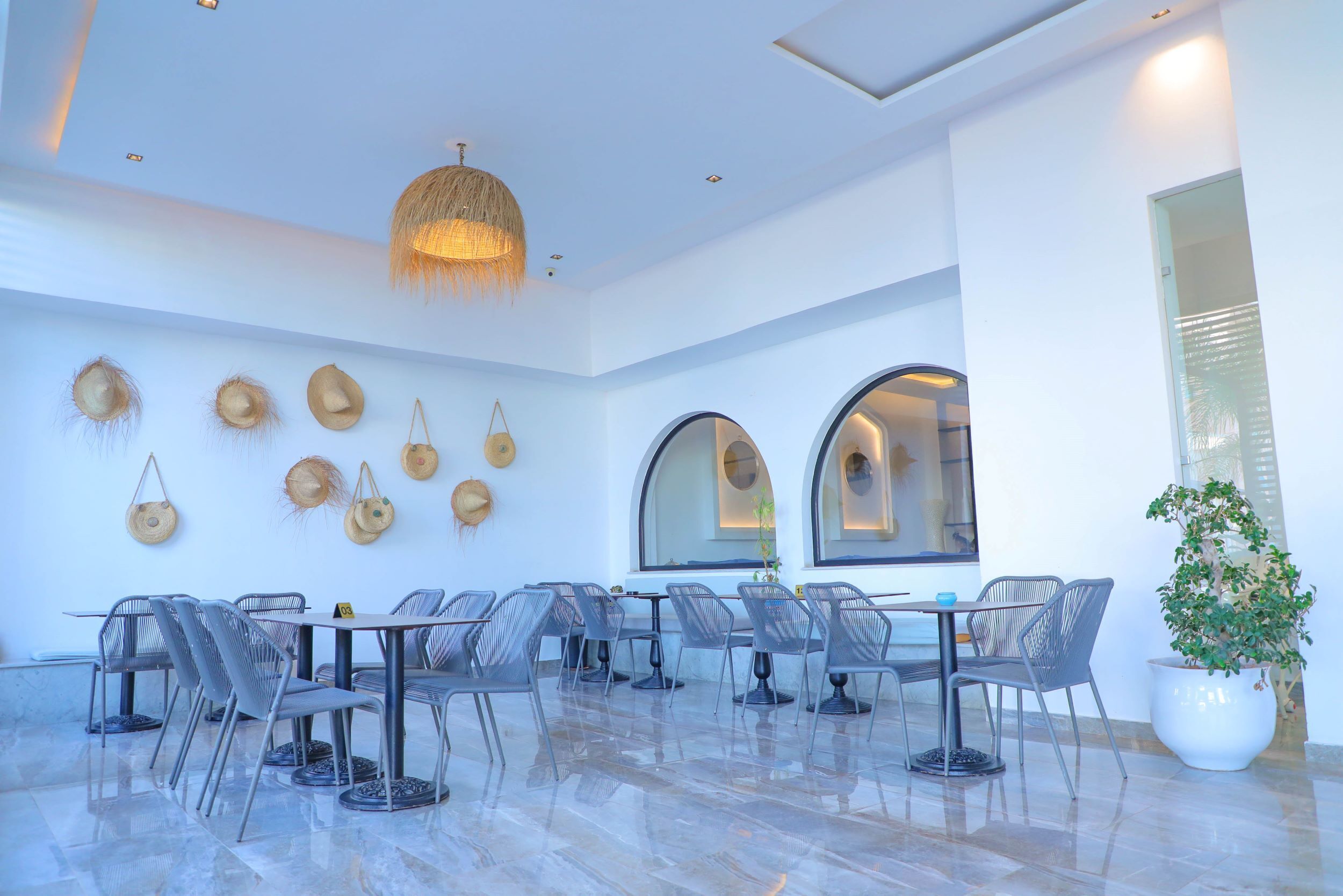 A spacious indoor area with a high ceiling, clear glass partitions, and a polished tile floor.