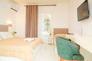 A hotel room with two beds, a desk, a chair, a TV, and a window with curtains. - Hôtel GAÏA (Nabeul)
