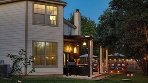A two-story house with a covered patio area, outdoor seating, and a grill. - 6 Bedroom Villa | Pool | Hot Tub Cabana (Austin)