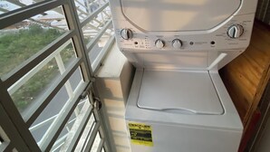 Eine Waschmaschine mit Frontlader in einem Zimmer mit großem Fenster.