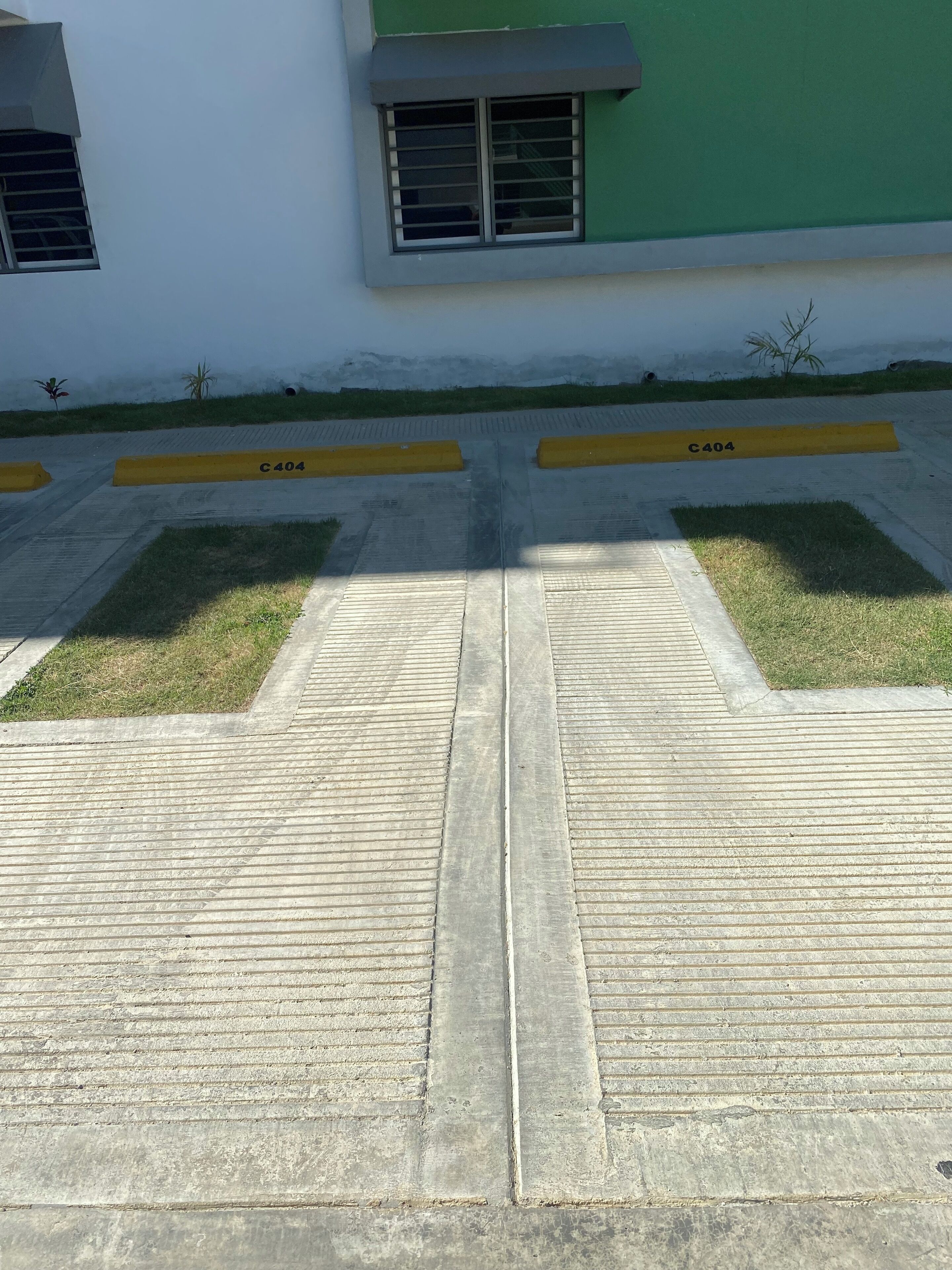 A concrete pathway leading to a building entrance with yellow curb markings labeled C404.
