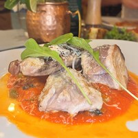 Un plato de comida con pescado y verduras sobre un plato blanco.