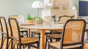 Un comedor con una mesa redonda dispuesta para seis personas, rodeada de sillas de mimbre.