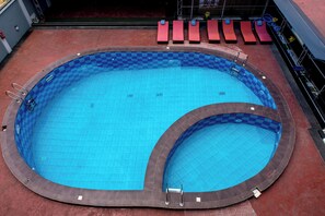 A large indoor swimming pool with a checkered pattern, surrounded by red lounge chairs and a red floor. - BON Hotel Hyatti Warri (Warri)