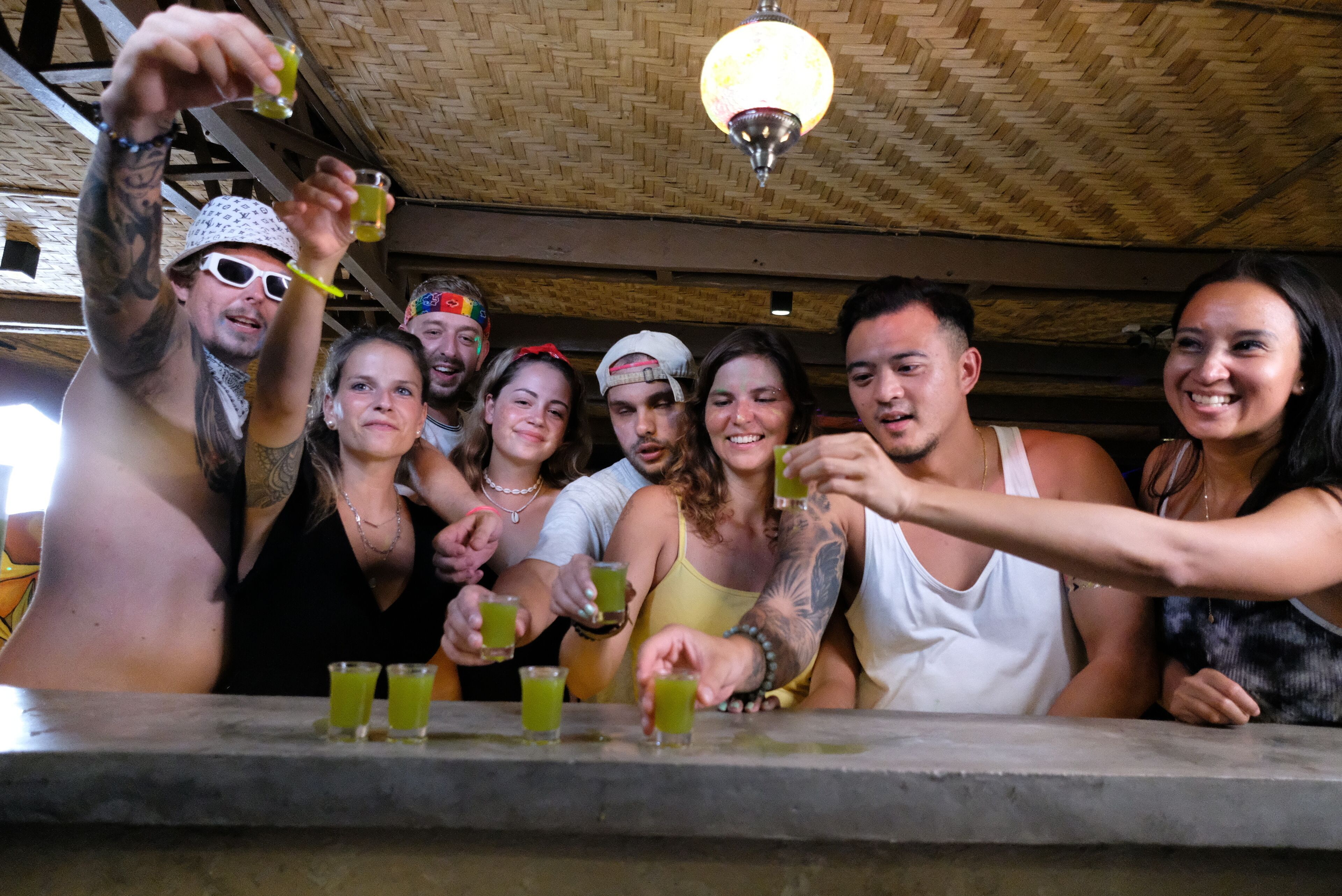 A group of people at a bar with drinks.