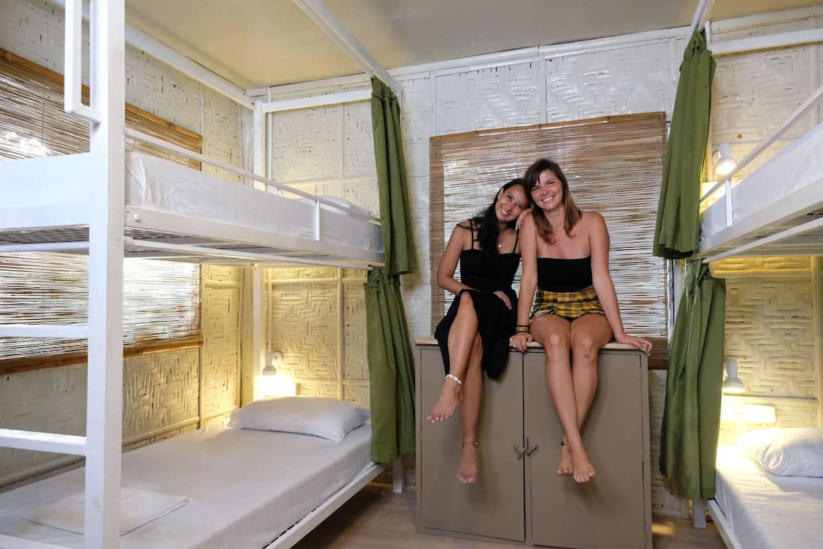 Quarto com beliche, duas meninas sentadas no beliche de cima.