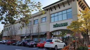 Un establiment Whole Foods amb un pàrquing i diversos cotxes a la façana.