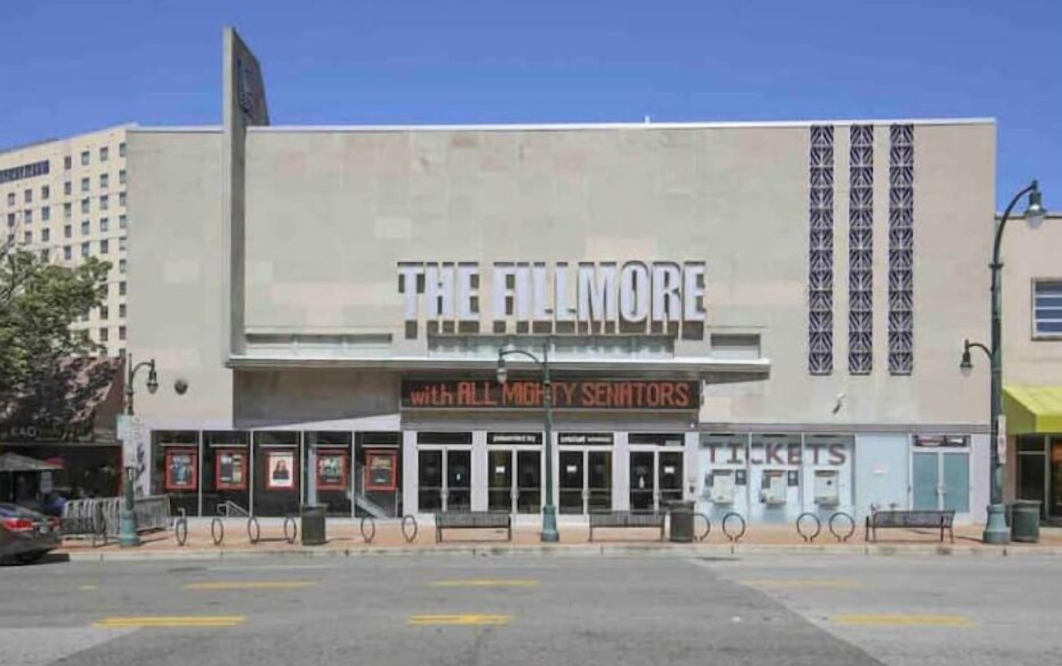 A theater with a marquee reading "THE FILMORE" and "WITH ALL MIGHTY SENATORS".