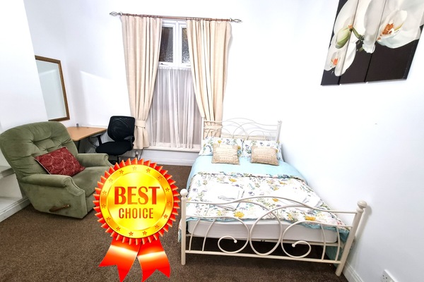 Cozy Retreat: Spacious double & single beds, work desk, and sofa armchair.