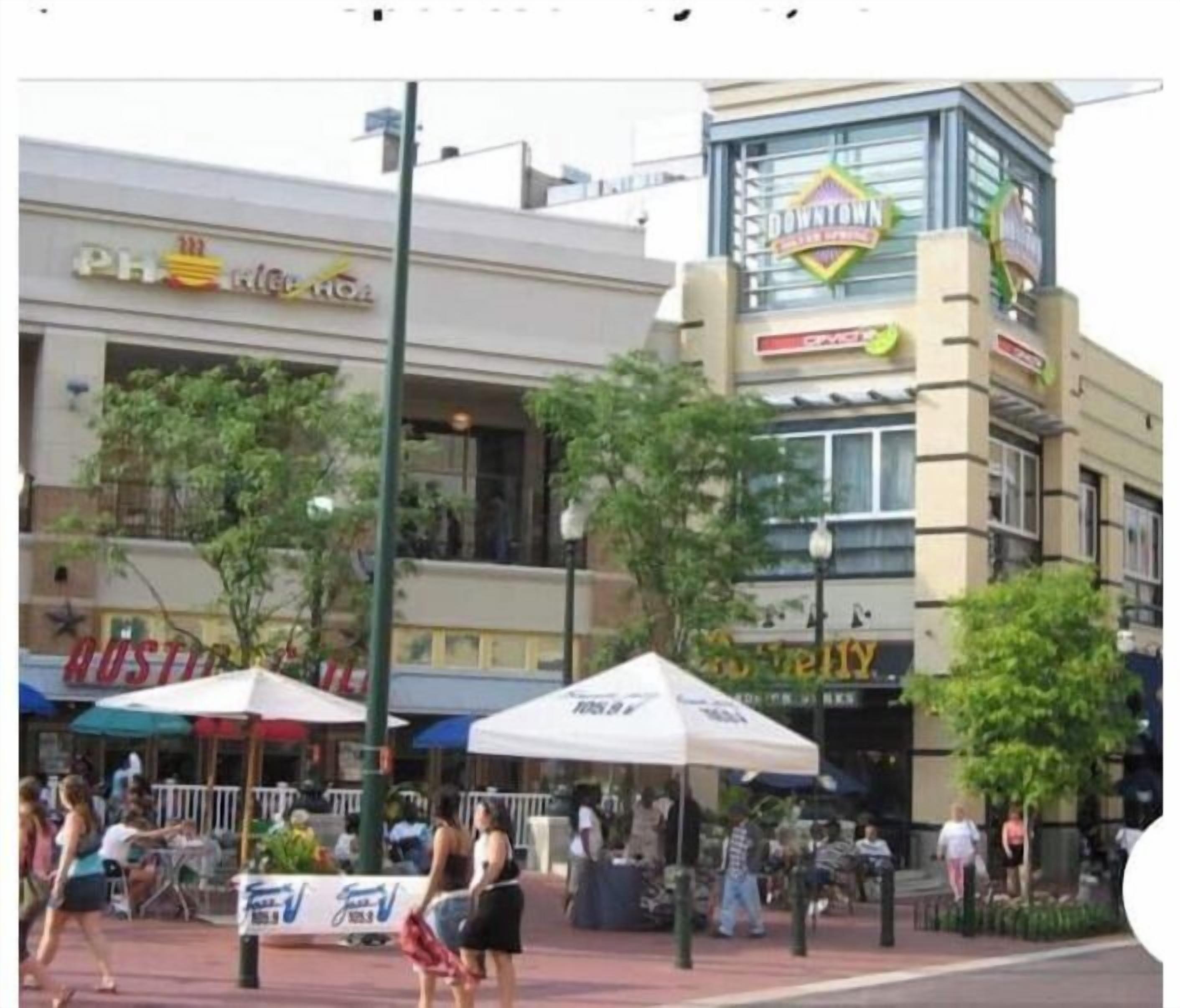 A commercial area with various storefronts, including a pharmacy and a restaurant.