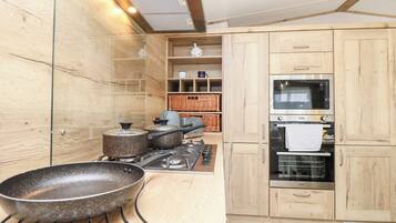 A modern kitchen with wooden cabinets, a gas stove, a microwave, and a built-in oven.