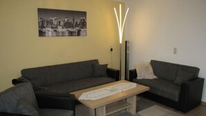 A living room with a sofa, a coffee table, and a floor lamp.