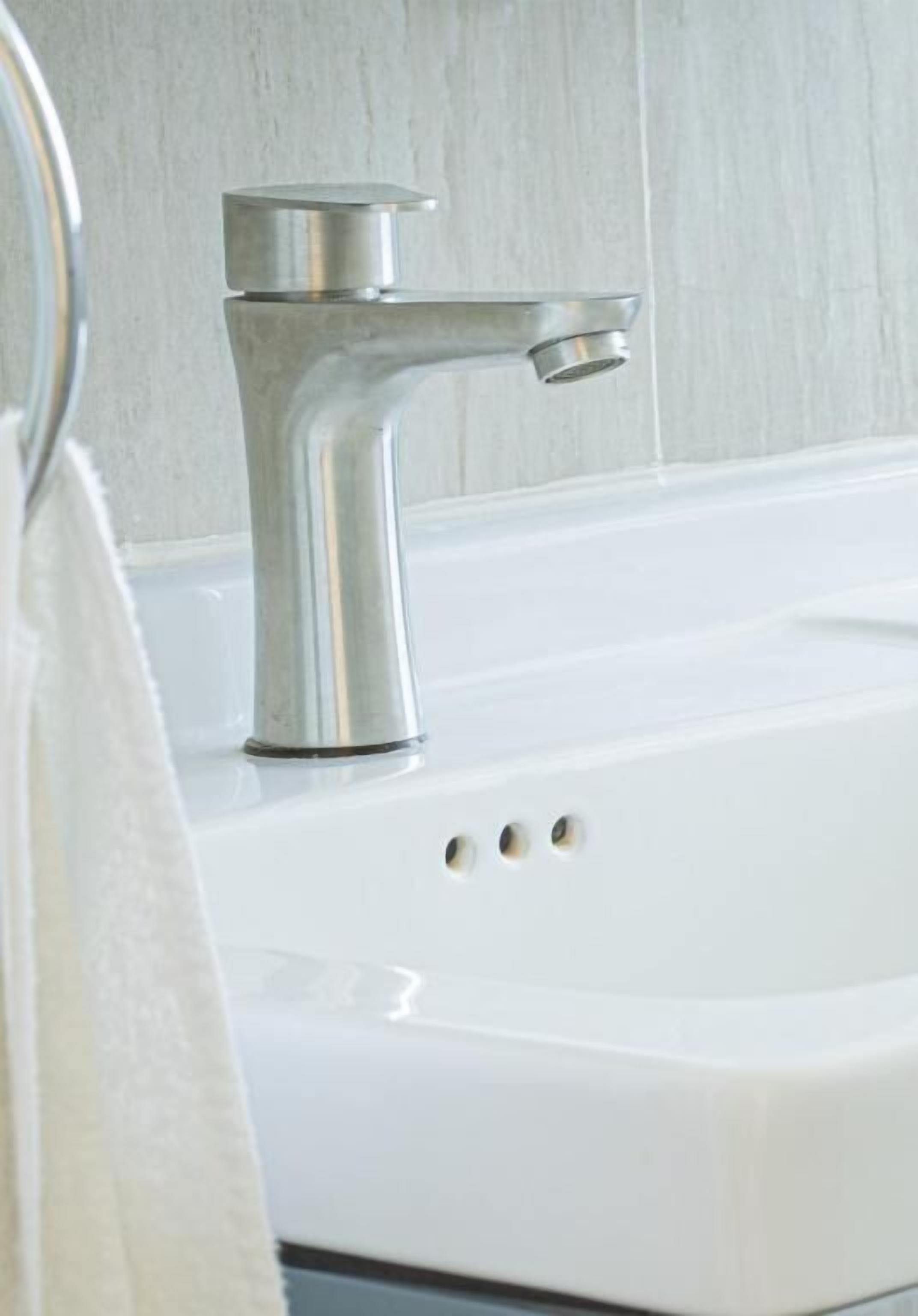 A modern bathroom with a white sink and a chrome faucet.