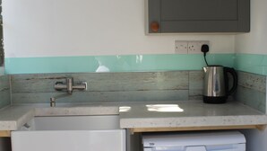 A compact kitchen with a sink, a kettle, and a small refrigerator. - The Pod Garden- Cozy Glamping Pod, Rural Location (Newquay)