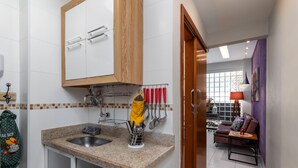 A compact kitchen with a granite countertop, a sink, and a wooden cabinet above. - Modern Studio Next to Arpoador Jc1012 Z2 (Rio de Janeiro)
