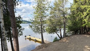 Eine Seeterrasse mit einer Holzsteganlage, die sich ins Wasser erstreckt, umgeben von Bäumen.