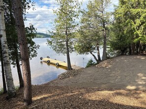 A lakeside deck with a wooden dock extending into the water, surrounded by trees. - Lake House Barry's Bay (Barry's Bay)