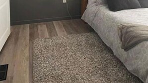 A bedroom with a forest-themed wall mural, a wooden headboard, and a patterned bedspread. - Lake House Barry's Bay (Barry's Bay)
