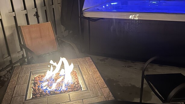 A fire pit with a wooden design, surrounded by chairs, and a hot tub in the background. - Cape Mindy HOT TUB Sleeps 8, Dog & EV Friendly, Outdoor Shower (Cape May)