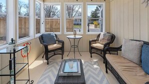 A sunroom with wicker furniture, large windows, and a ceiling fan. - Cape Mindy HOT TUB Sleeps 8, Dog & EV Friendly, Outdoor Shower (Cape May)