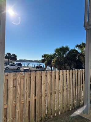 A wooden fence, a clear sky, and parked vehicles in the background.